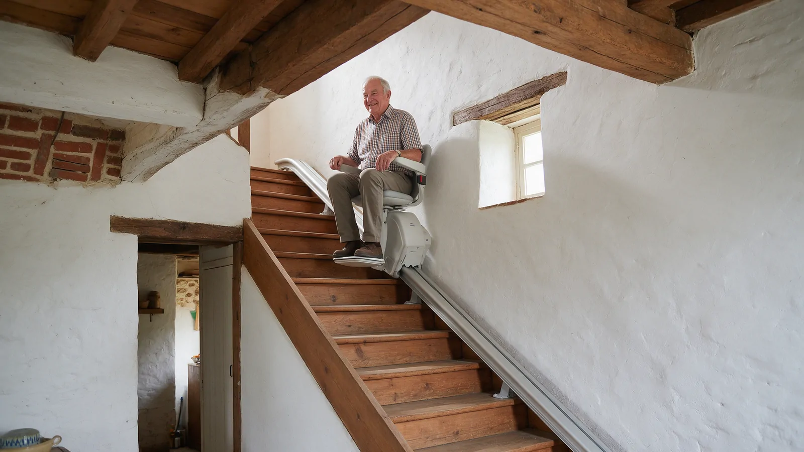 Homme âgé arrivant en haut de l’escalier raide d’une maison en brique sur un monte-escalier